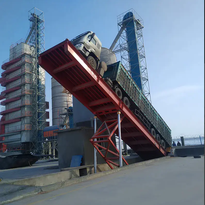 Truck dumper platform raised during a bulk material unloading operation